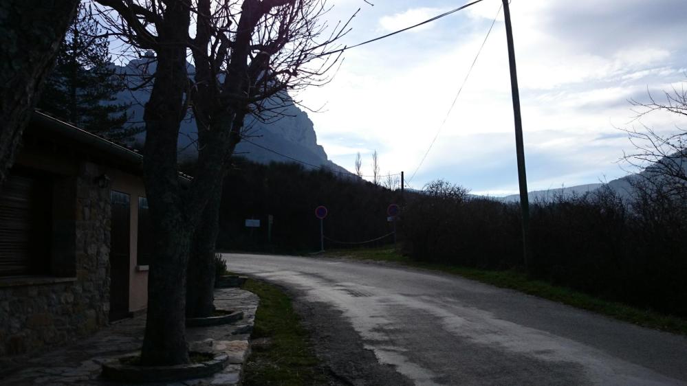 Route de sortie du village, en toile de fond le massif du Bugarach se profile